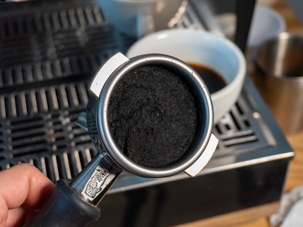 portafilter po extrakci nejtmavěji pražené kávy